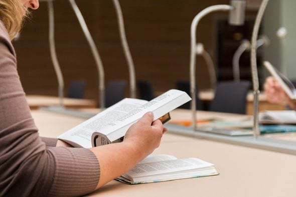 Lesende Frau in einer Bibliothek